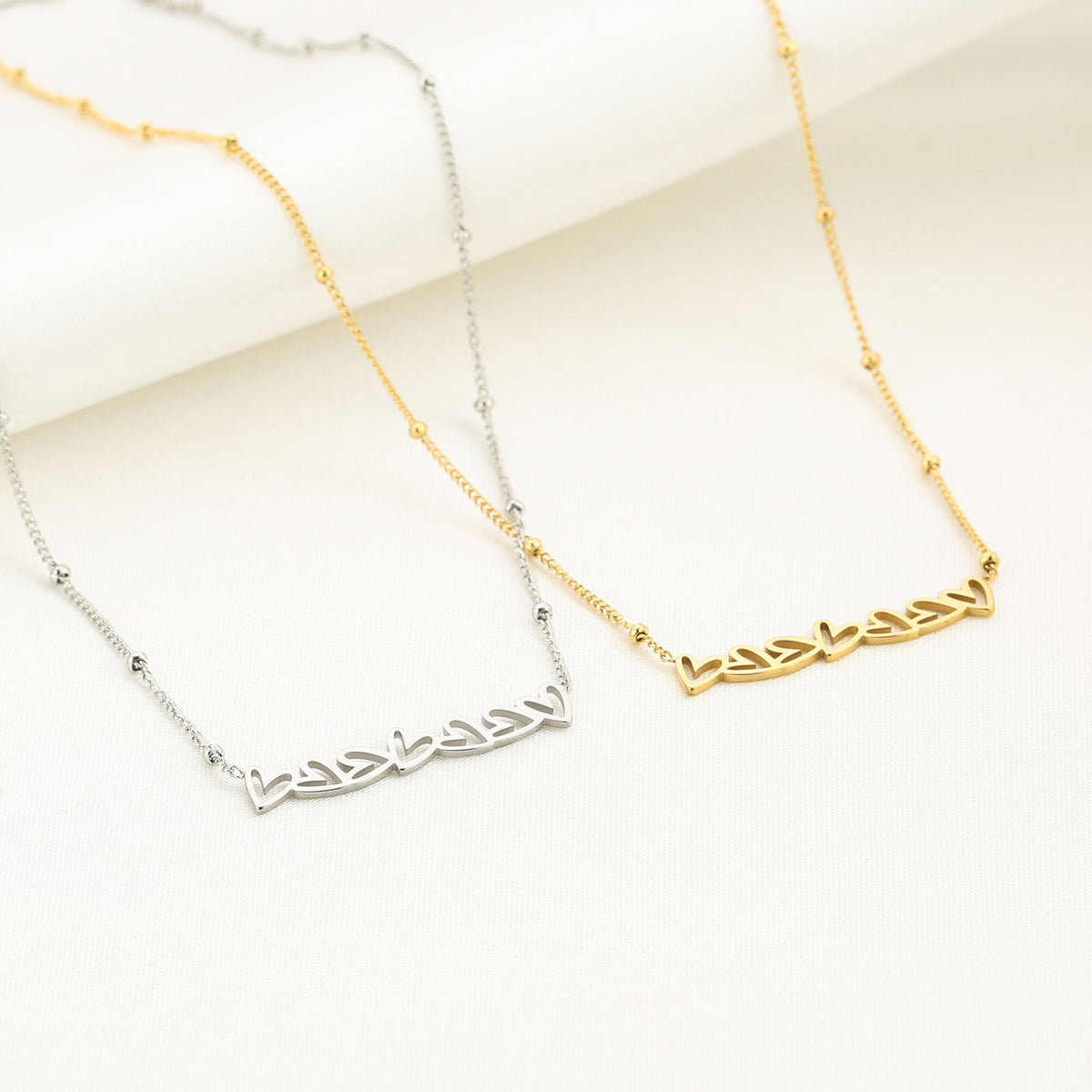 Ketting met zeven hartjes van stainless steel, naast elkaar in zilver en goud